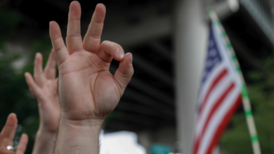 A demonstrator makes a hand gesture believed to have white supremacist connotations, Aug. 17, 2019, in Portland, Oregon, United States
