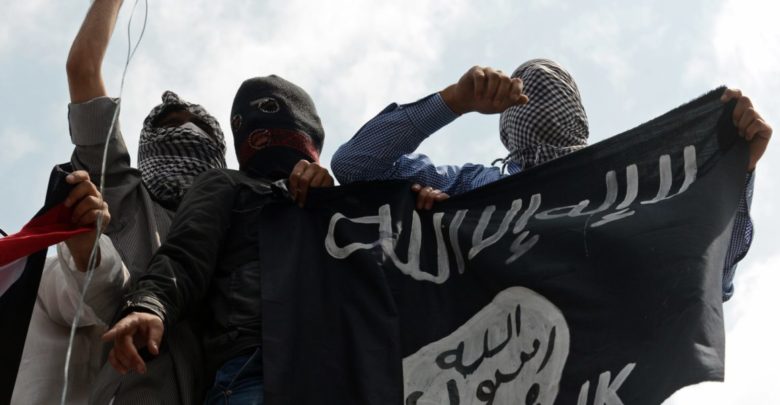 Islamic State supporters hold up the caliphate's flag