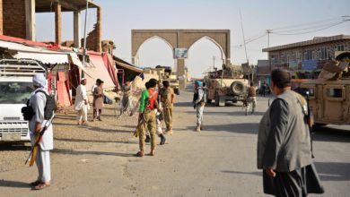 Afghan security forces stand along a road during clashes against Taliban militants Aug. 12, 2018