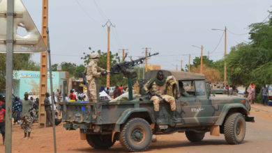 Malian soldiers ride on a pick up truck with a machine gun on November 13, 2018, in Gao