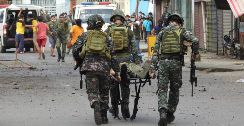 Military personnel carry an injured victim after the twin bombing in Philippines.
