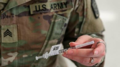 A US army personnel holds a vaccine