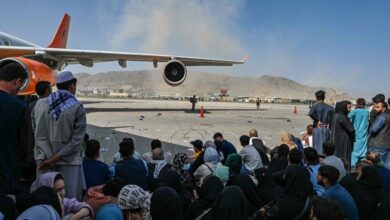 Afghan people wait to leave the Kabul airport on August 16, 2021