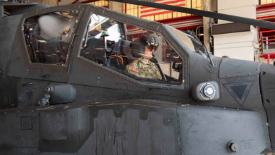 A US Army pilot observes the features of an enhanced Helmet Mounted Display from the front seat of an AH-64E Apache Helicopter