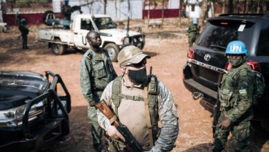 A Rwandan peacekeeper alongside a Russian private security guard