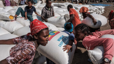 Women carry sacks of wheat during a distribution of food organized by the Ethiopian government