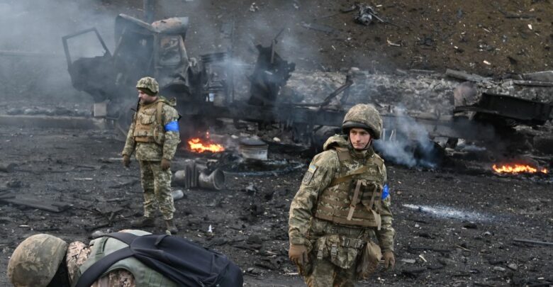 Ukrainian service members look for and collect unexploded shells after a fighting with Russian raiding group in the Ukrainian capital of Kyiv