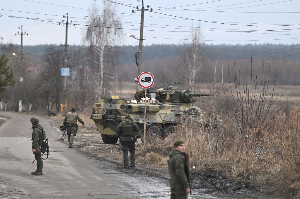 Ukrainian servicemen stand near an armored personnel carrier BTR-3