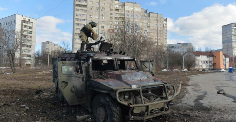 A Ukrainian Territorial Defense fighter examines a destroyed Russian infantry mobility vehicle GAZ Tigr after the fight in Kharkiv
