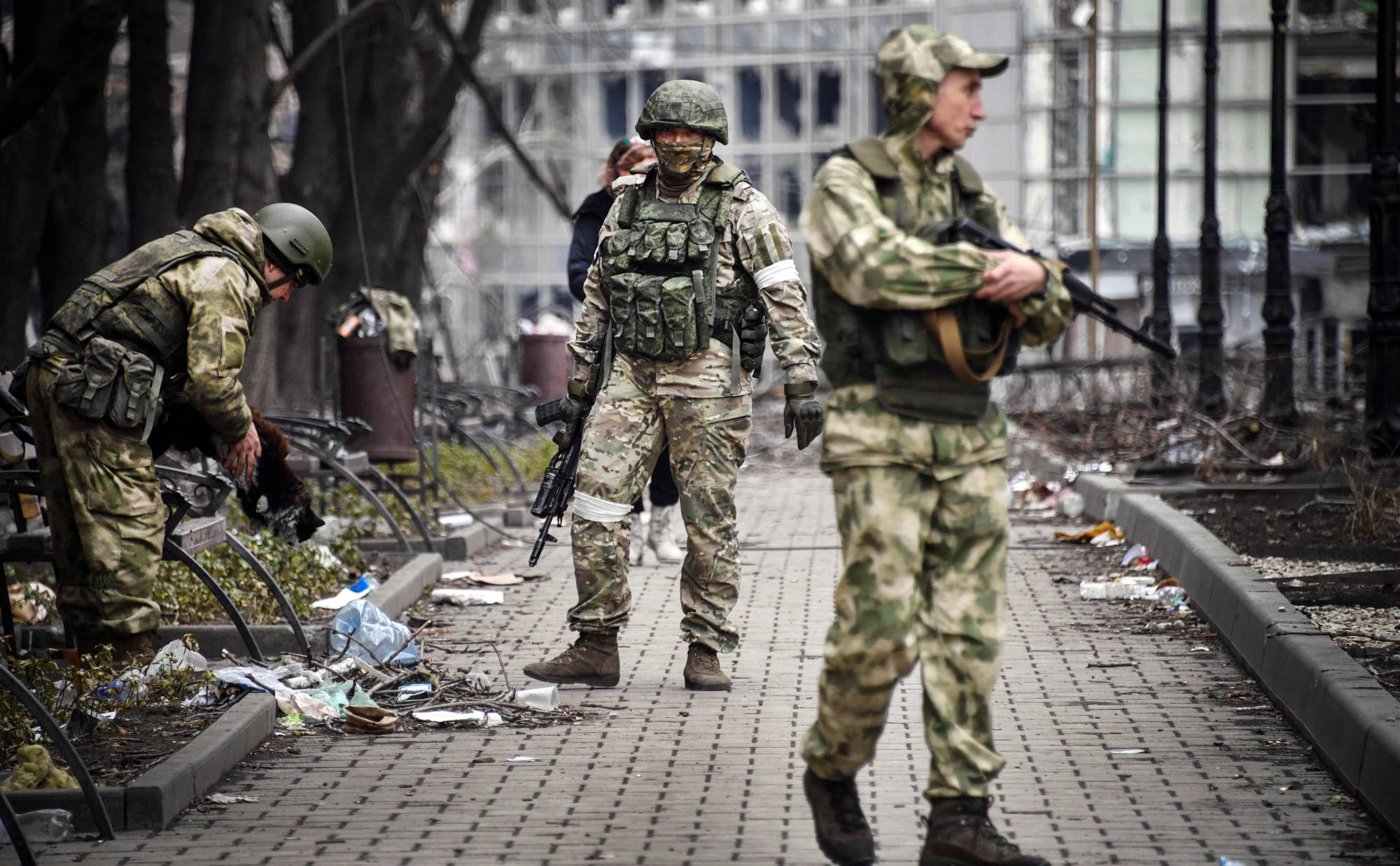 Russian soldiers walks along a street in Mariupol