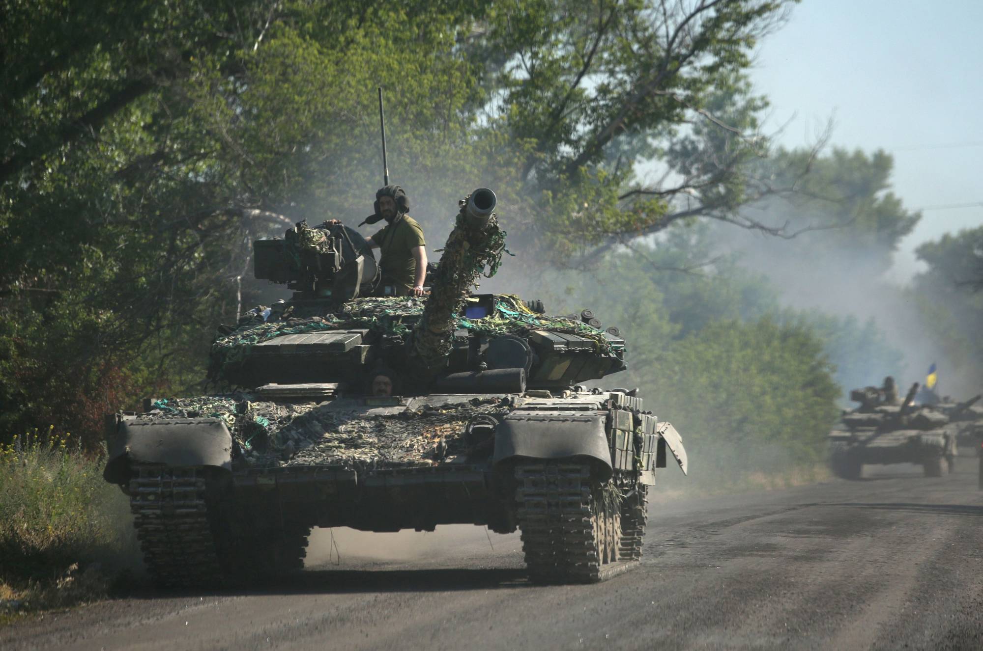 Ukrainian troop move by tanks on a road