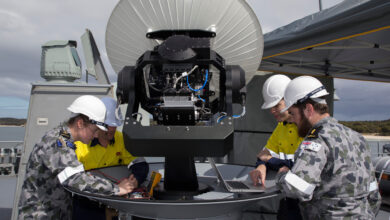 Royal Australian Navy sailors assemble SATCOM for maritime WiFi connection.