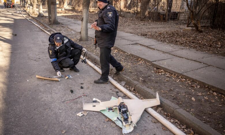 Ukrainian police officers inspect a downed Russian drone after a strike in northwestern Kyiv