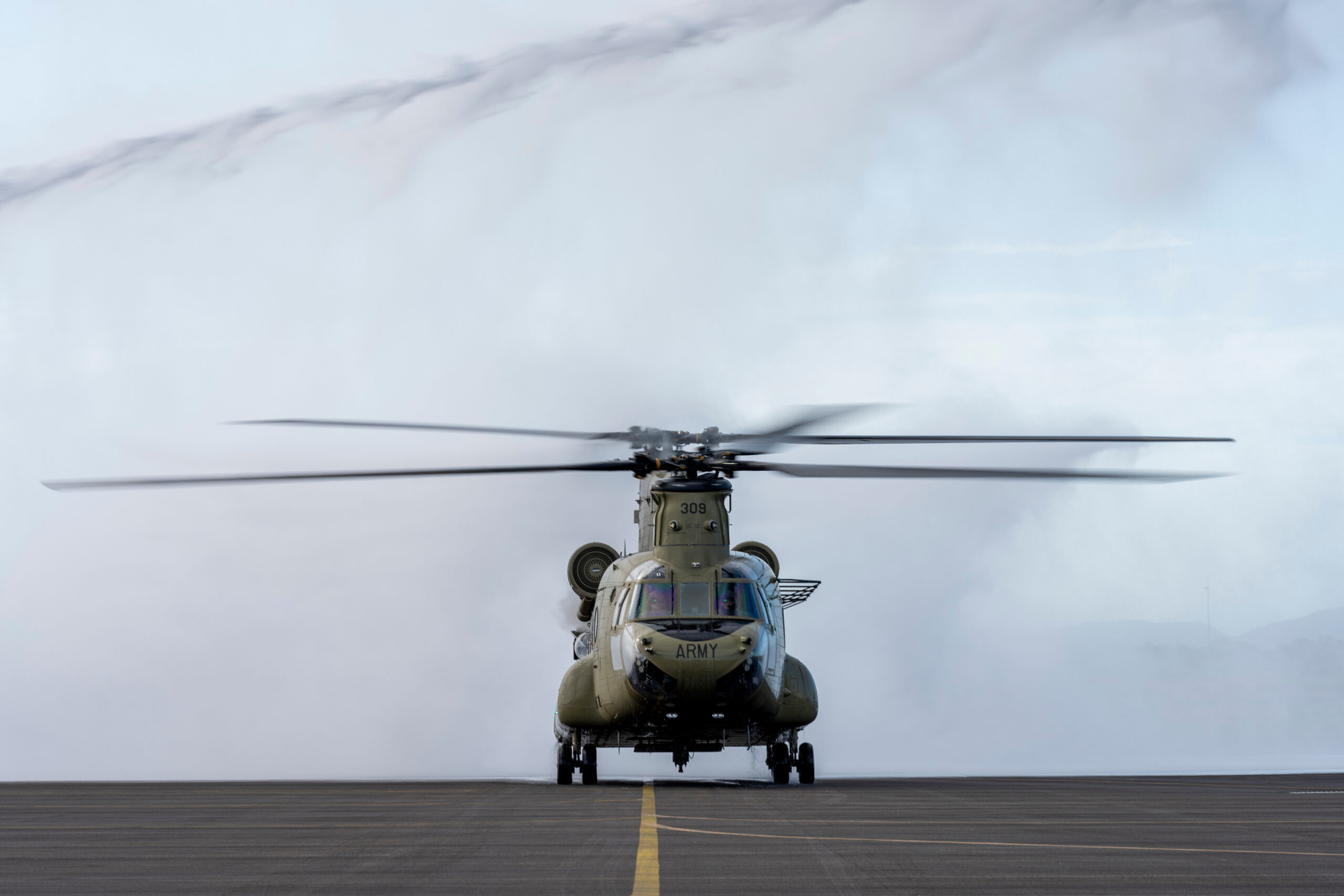An Australian Army CH-47F Chinook helicopter from the 5th Aviation Regiment taxis through a water arch to celebrate Boeing Aircrewman Instructor, Andrew Fieldhouse as he completes a final flight in the CH-47 Chinook at RAAF Base Townsville, Queensland. *** Local Caption *** On 29 June 2022, before his retirement former Australian Army and now Boeing Aircrewman Instructor, Andrew Fieldhouse took one last flight in a 5th Aviation Regiment Chinook helicopter. In recognition of his years of service, the Townsville Airfield Rescue and Fire Fighting team provided a Water Arch Salute where he was greeted by well-wishers to mark the final flight. Andrew Fieldhouse served a total of 40 years of which 30 were served with the Army Aviation capability.