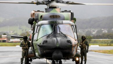 Royal Australian Navy aircrew from the 808 Squadron, stand beside their MRH90 Taipan helicopter in Wollongong, Australia