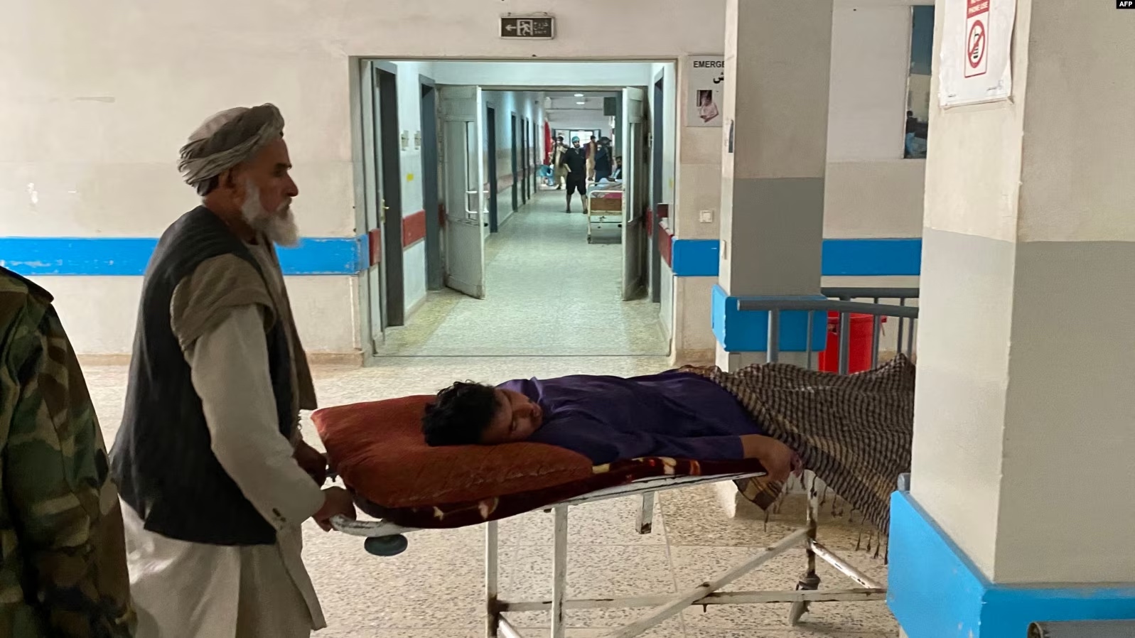 Men shift a wounded man inside a hospital in Mazar-i-Sharif on March 9, 2023, following a suicide attack at the office of the Taliban governor of Afghanistan's Balkh province