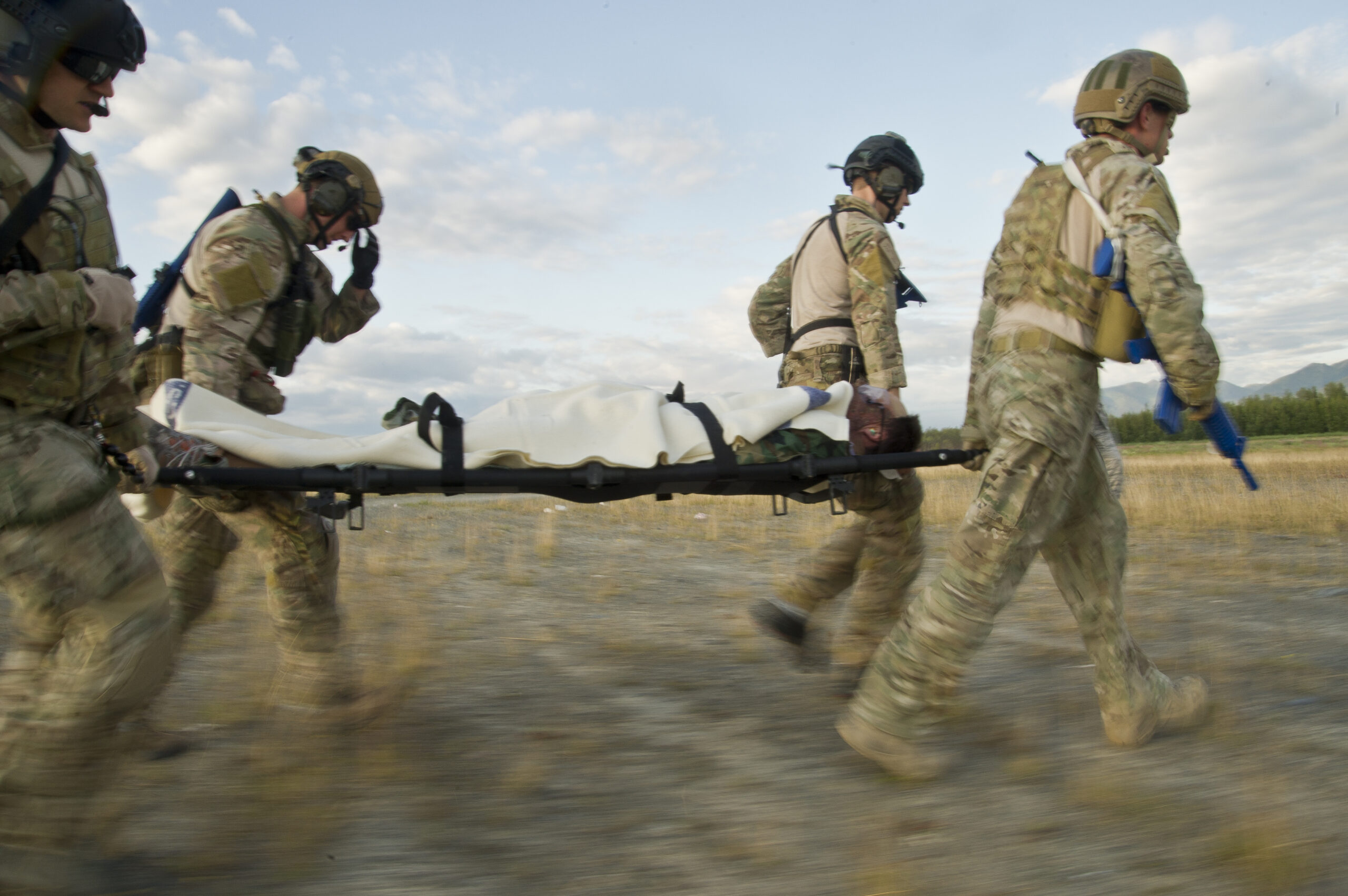 U.S. Air Force pararescuemen also known as PJs (para-jumpers) from the, Alaska Air National Guard Joint Base Elmendorf-Richardson, Alaska, and (Pararescue/Guardian Angels) from Davis Monthan AFB, Tucson, Ariz., transport a wounded body during simulated mass casualty combat training scenario July 30, 2014.