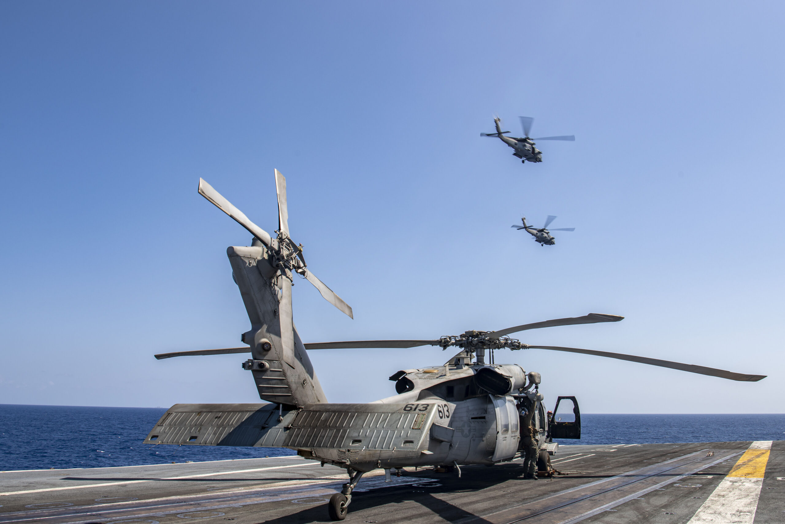 230512-N-BI507-1130 PHILIPPINE SEA (May 12, 2022) Two MH-60R Sea Hawk helicopters from the "Battlecats" of Helicopter Maritime Strike Squadron (HSM) 73 fly near the aircraft carrier USS Nimitz (CVN 68) during an aerial change of command ceremony. Nimitz in U.S. 7th Fleet conducting routine operations. 7th Fleet is the U.S. Navy's largest forward-deployed numbered fleet, and routinely interacts and operates with allies and partners in preserving a free and open Indo-Pacific region. (U.S. Navy photo by Mass Communication Specialist 3rd Class Carson Croom)