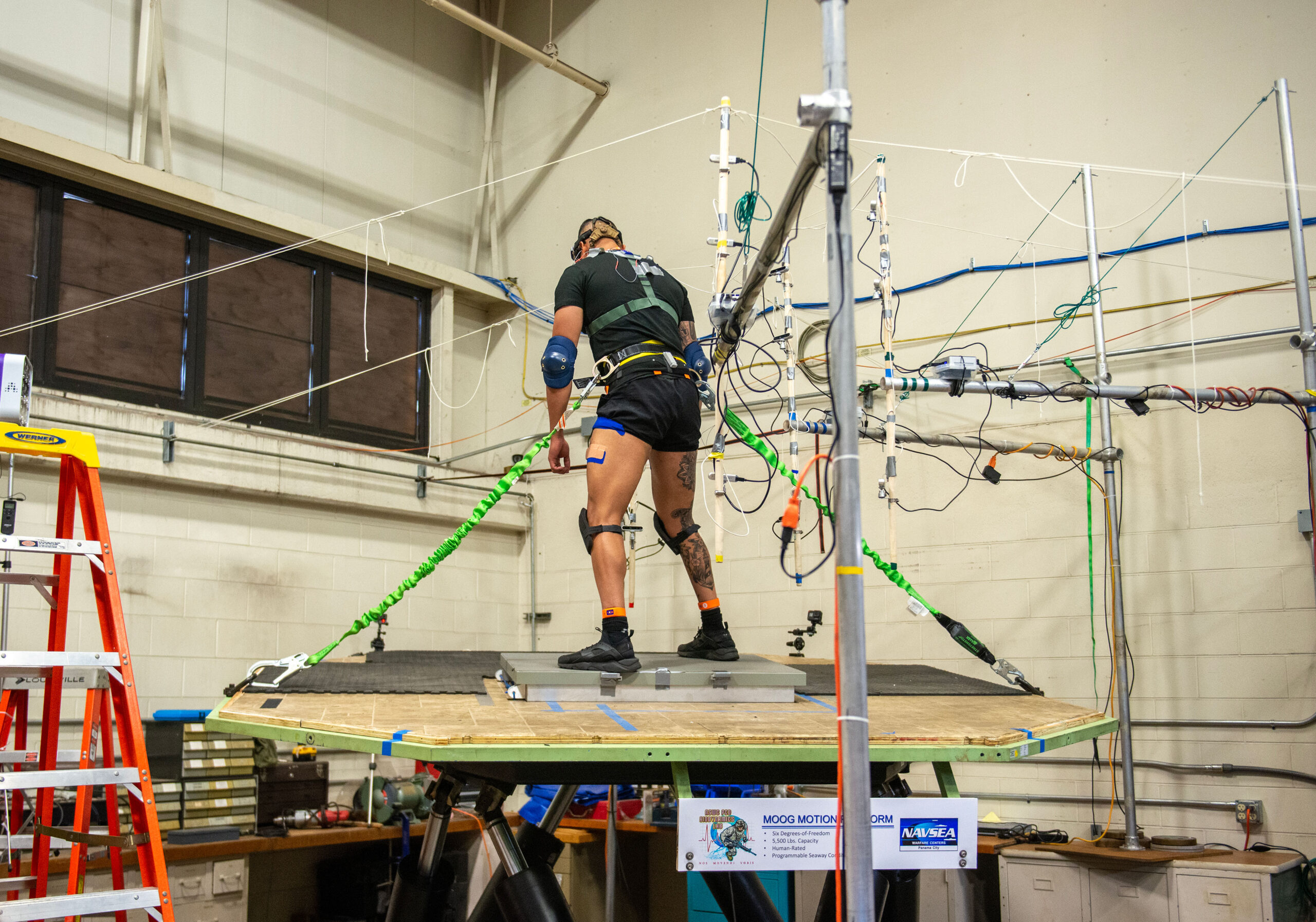 A US Coast Guard Test Participant is free standing on a Moog 6DOF motion simulator while being exposed to simulated Sea State III conditions