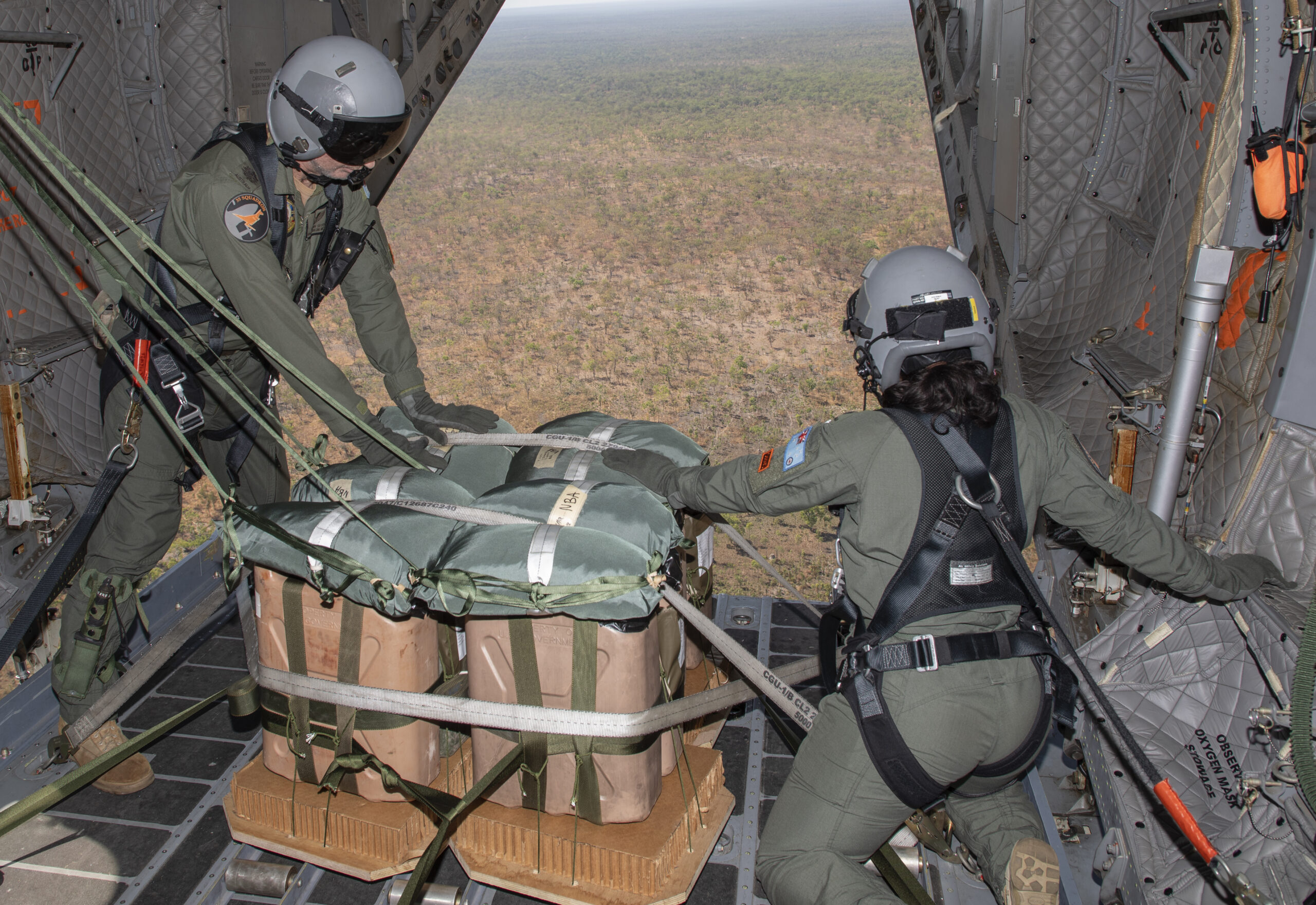 (l-r) No.35 Squadron loadmasters Warrant Officer Shaunn Segon and Corporal Mackenzie Golightly prepare to perform an airdrop over Mt. Bundy Range in the Northern Territory. *** Local Caption *** On 22 July 23, No. 35 Squadron (35SQN) completed interoperability training with Marine Rotational Force Darwin, conducting two airdrop flights over Mount Bundy Training Area in the Northern Territory. The C-27J Spartan dropped four Light Equipment and three Container Delivery System loads each flight. The United States Marine Corps personnel conducted the Drop Zone survey, constructed the airdrop loads, and performed drop zone safety officer duties on the ground, enabling the airdrop to occur. This training achieved further synergy between Australia and partner nations, strengthening our important partnership with the United States. 35SQN is located at RAAF Base Amberley, Queensland, with a C-27J is currently based in Darwin for Exercise Talisman Sabre until early August.