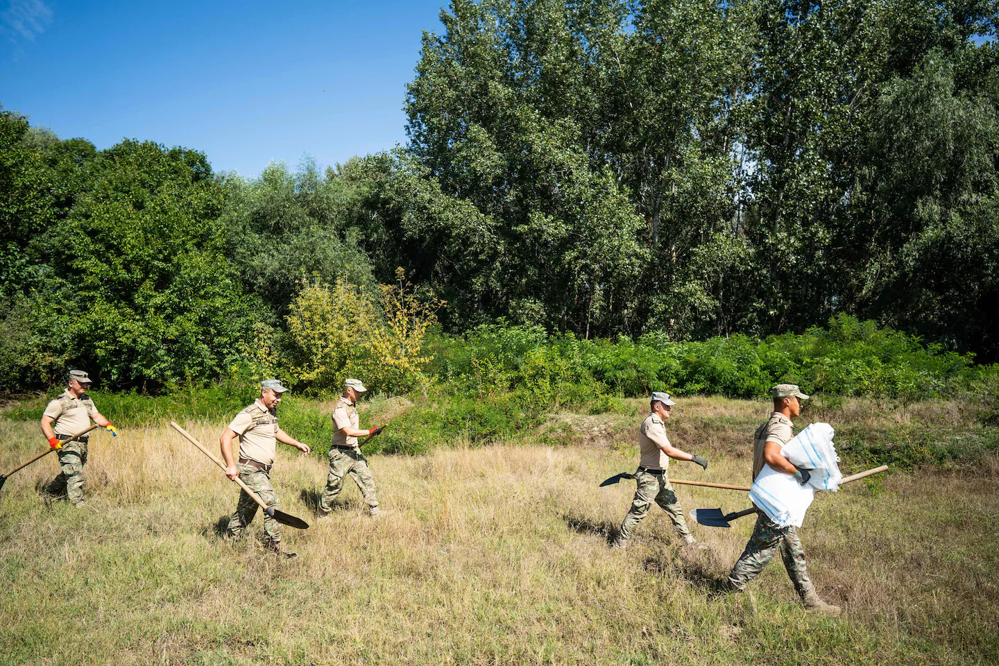 Romanian soldiers build a bomb shelter for residents in the village of Plauru near the border with Ukraine