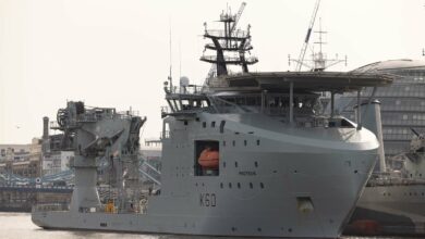 RFA Proteus is seen docked in London. HMS Belfast, an old UK wartime ship, is seen in the background beside Proteus.