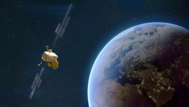 A rendering of a Skynet satellite in space. On the left, the satellite is seen hovering above Earth, which is seen on the right.