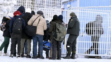 Finnish Border Guards check the documents of arriving migrants at the international border crossing at Salla, northern Finland