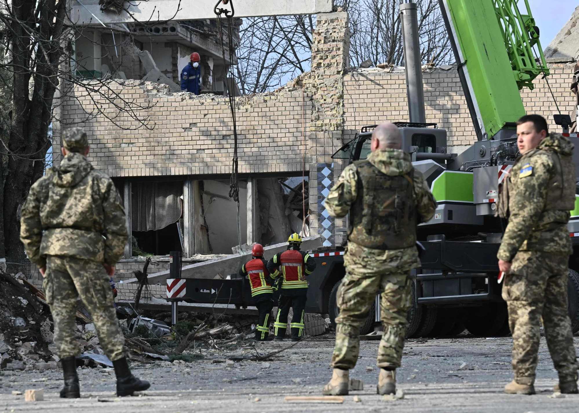 Rescuers clear debris at a partially destroyed building after an air strike in the town of Rzhyshchiv, in the Kyiv region on March 22 amid the Russian invasion of Ukraine