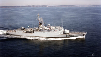 A photo of the French Navy's aviso Lieutenant de vaisseau Lavallée ship. The ship, painted light grey, is sailing in deep blue waters. A fair, cloudless sky acts as the background.