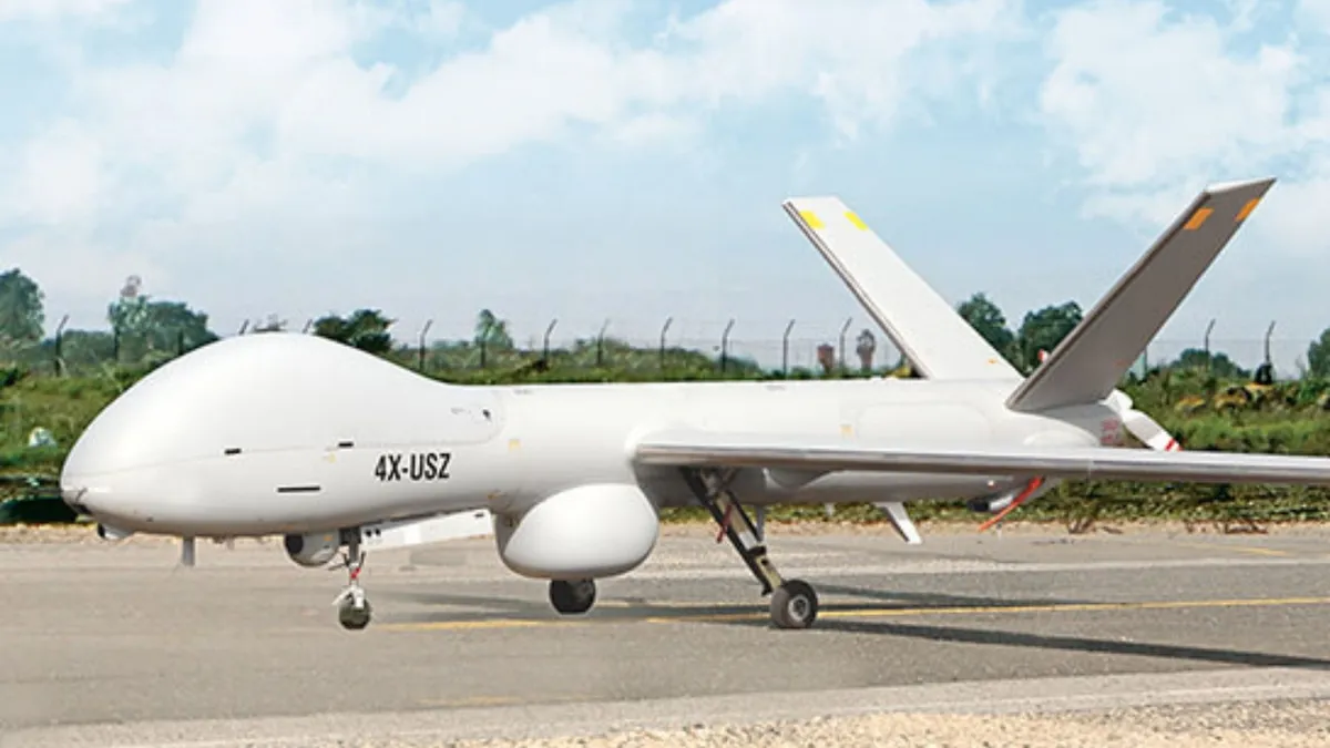 An Hermes 900 MALE drone is seen on the ground in what appears to be a runway. The white aircraft has 4X-USZ written on its left side in black paint.