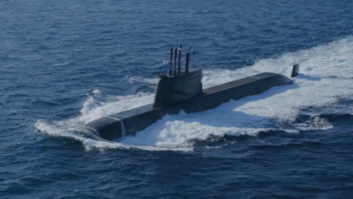 ROKS Dosan Ahn Changho (SS-083), a Jangbogo-III class submarine, is seen floating half-submerged in deep blue waters. The ship is painted black. A South Korean flag is seen hoisted up on a pole on top of the submarine's sail.