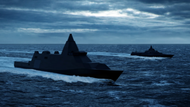 An artist's rendition of the Luleå-class vessel, sailing beside the smaller Visby corvette. The ships are moving in relatively calm but deep blue waters. The sky is extremely cloudy, covering most of the sun's light.