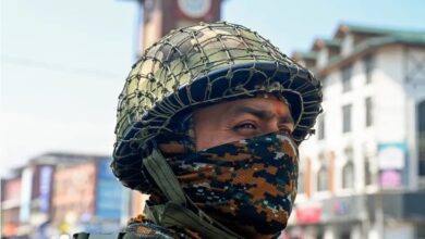 An Indian paramilitary trooper stands guard along a street in Srinagar.
