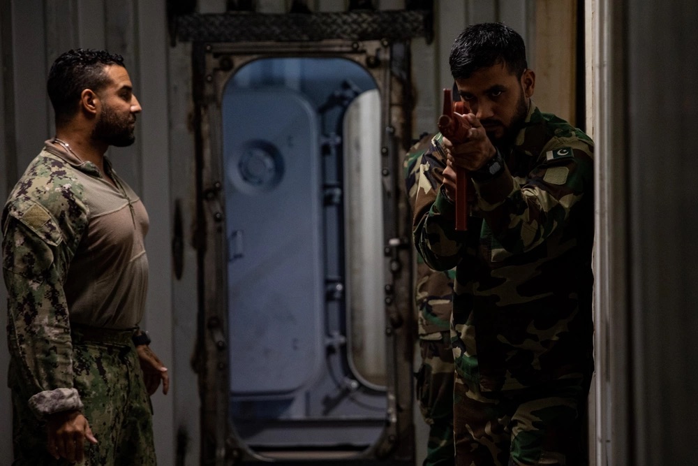A US Coast Guard Maritime Law Enforcement Specialist oversees Pakistan Navy members during a visit, board, search and seizure training