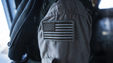 A CH-53E super stallion crew chief assigned to Marine Heavy Helicopter Squadron 463 "Pegasus," brandishes a coyote American flag patch on his uniform during a flight around Oahu, Hawaii, Sept. 23, 2014. The crew of the CH-53E conducted a single-point external lift of a decommissioned Navy A-4 skyhawk from Barber's Point to Joint Base Pearl Harbor-Hickam, Hawaii for the Wings Over the Pacific 2014 air show to be used as a static display. (U.S. Marine Corps Photo by Cpl. Matthew Callahan/ Released)