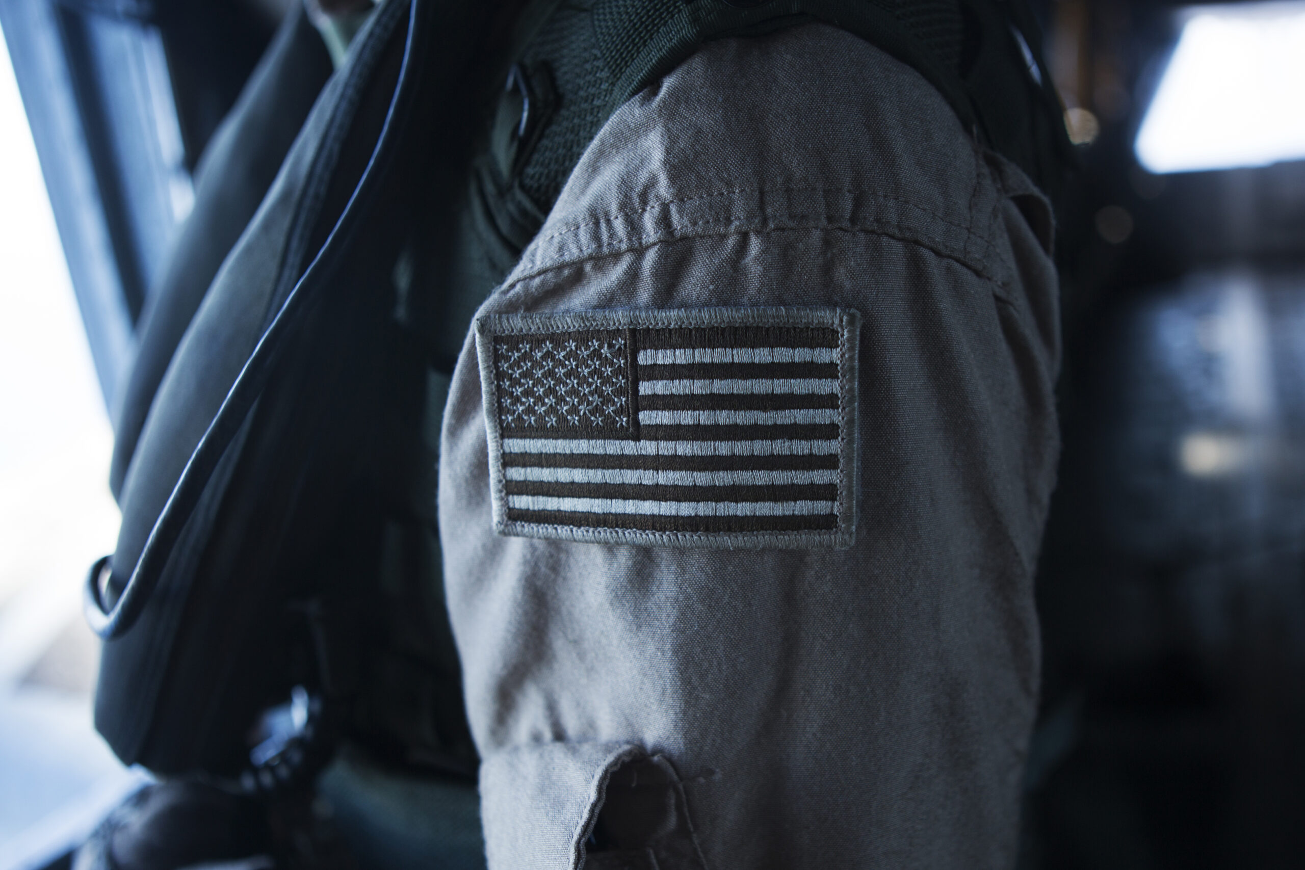 A CH-53E super stallion crew chief assigned to Marine Heavy Helicopter Squadron 463 "Pegasus," brandishes a coyote American flag patch on his uniform during a flight around Oahu, Hawaii, Sept. 23, 2014. The crew of the CH-53E conducted a single-point external lift of a decommissioned Navy A-4 skyhawk from Barber's Point to Joint Base Pearl Harbor-Hickam, Hawaii for the Wings Over the Pacific 2014 air show to be used as a static display. (U.S. Marine Corps Photo by Cpl. Matthew Callahan/ Released)
