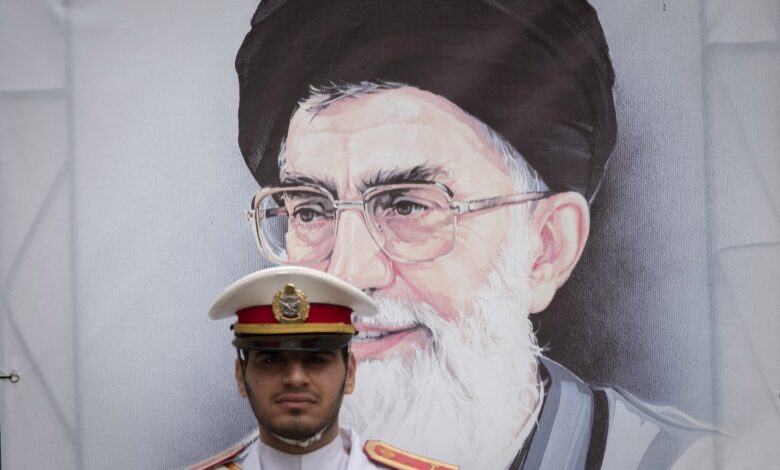 A member of an Iranian Army honor guard stands at attention in front of a portrait of Iran's Supreme Leader, Ayatollah Ali Khamenei, during a ceremony