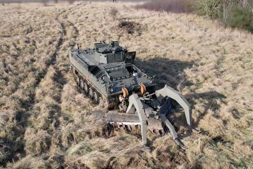 The remote-controlled robotic mine plough system "Weevil" attached to a military vehicle moving through a field