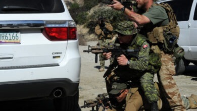 Shawn Lewis, a Tactical Firearms Training Team instructor, top, Canadian armed forces Master Cpl. Patrick Blanchard (center), and Mass Communication Specialist 1st Class Peter Lewis practice returning fire during a convoy ambush as part of Fleet Combat Camera Pacific's Winter Quick Shot 2013 combined field-training exercise in the Angeles National Forest near Azusa, Calif., Feb. 15. Quick Shot is a semi-annual exercise that improves combat camera service members' ability to operate in a tactical environment. (U.S. Navy photo by Mass Communication Specialist 1st Class Mike Lenart/Released)