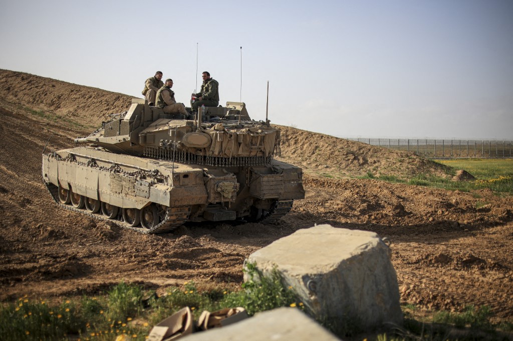 Israeli military forces patrolling on a tank near Gaza