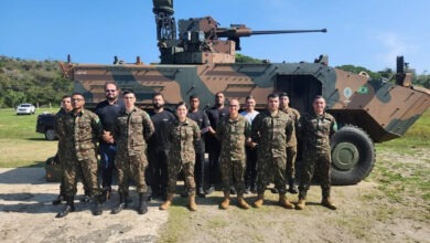 Brazilian Army and ARES personnel in front of a UT30BR-equipped Guarani armored personnel carrier