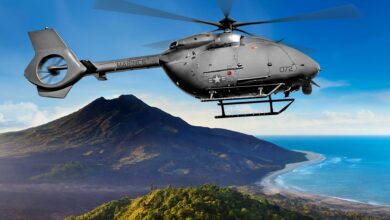 A brightly colored background with a mountainous terrain featuring the MQ-72C helicopter