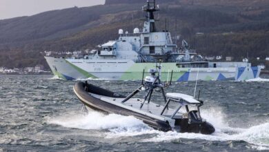 Autonomous Rattler boat operating alongside a Royal Navy warship during open-sea trials off the coast of Scotland