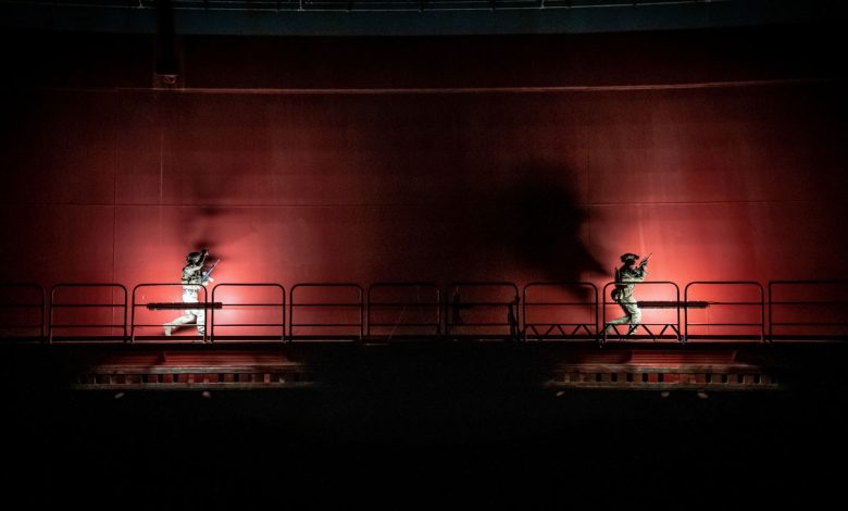 NATO special operations forces conduct a nighttime training exercise during Exercise Nighthawk 21, moving along an industrial platform under red lighting.