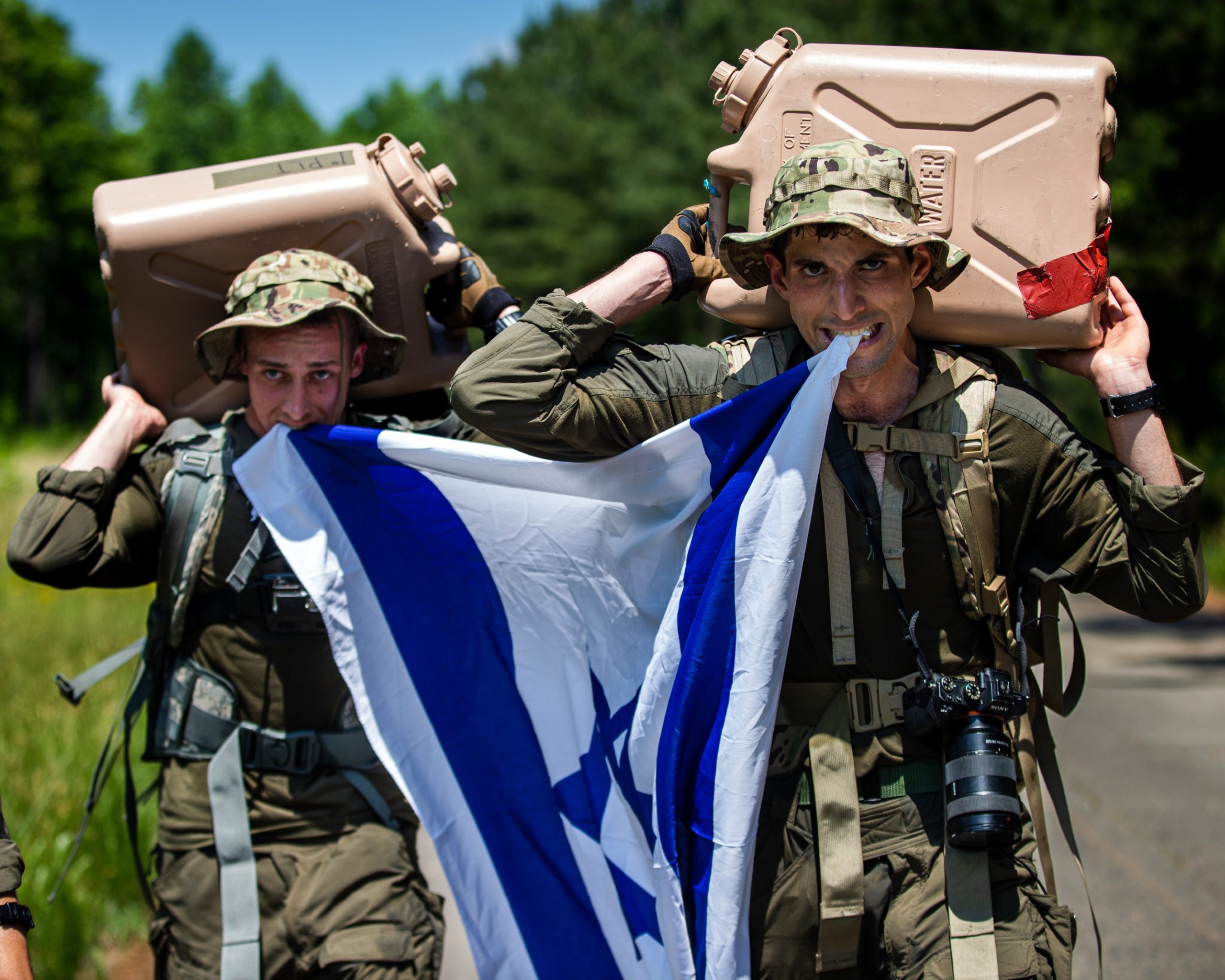 Israel Defense Forces Sgt. Yuval Chen and Sgt. Daniel Yastrijemski, visual information specialists assigned to Israel Defense Forces Combat Camera Unit, participate in "The Hunter," a culminating event that includes a two mile run, a three mile ruck, and a one mile water jug carry while competing in the 2022 Spc. Hilda I. Clayton Best Combat Camera Competition at Fort A.P. Hill, Virginia, May 22, 2022. The annual multi-day competition tests the tactical and technical proficiency of visual information and public affairs specialists across the DOD and participating international competitors. (U.S. Army photo by Spc. Rhianna Ballenger)