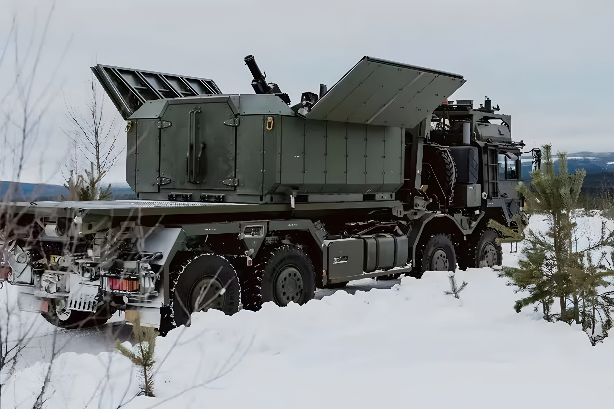 Rheinmetall Ragnarok 120mm truck-mounted mortar with open roof panels positioned in a winter landscape, showcasing its shoot-and-scoot mobile fires capability